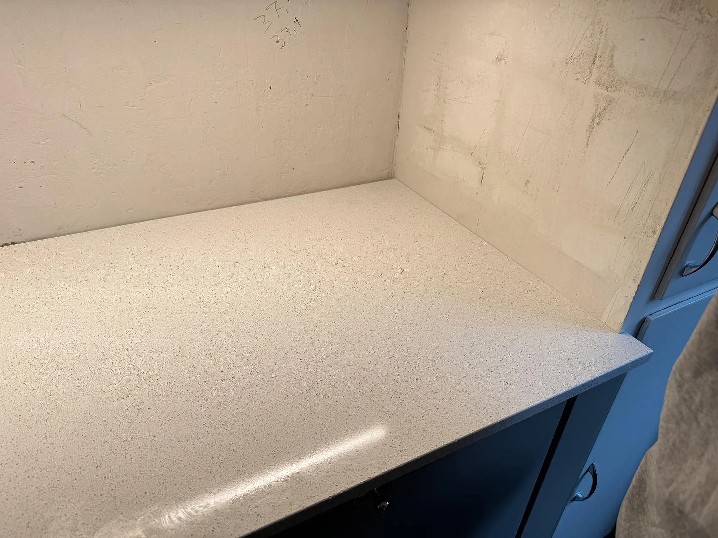 Detalj av den polerade ljusa ytan i Silestone Blanco Maple 14 på en köksbänk mot mörka fronter i Malmö.