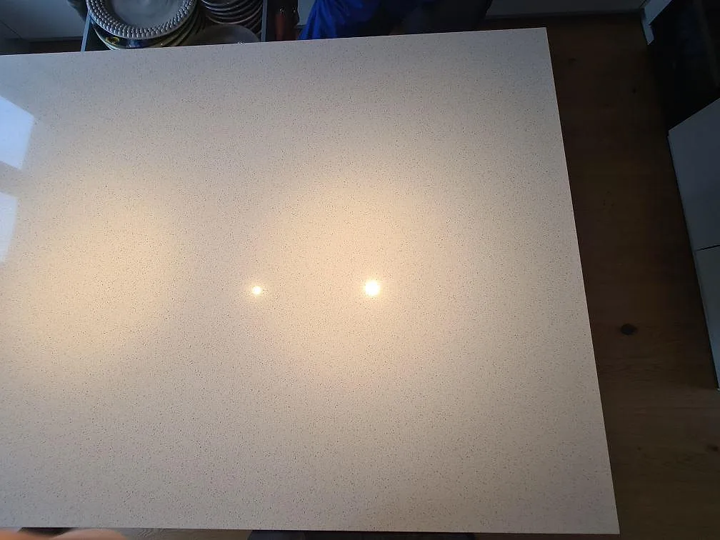 Närbild av polerad Silestone Blanco Maple 14 komposit på köksö med fin ljus struktur i Stockholm.