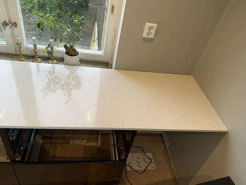 Sidobänk i Silestone Blanco Orion med polerad ljus yta vid fönster och öppna köksstommar i Malmö.
