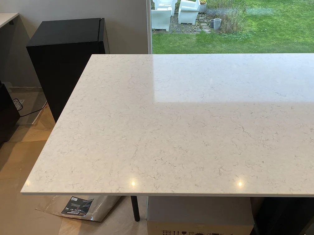 Stor polerad yta av Silestone Blanco Orion på köksö med ljus ådring och mörka stommar i Malmö.