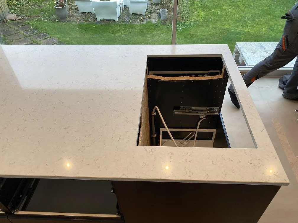 Närbild på ljus Silestone Blanco Orion köksö med polerad yta, grå ådring och öppet urtag vid fönster i Malmö.