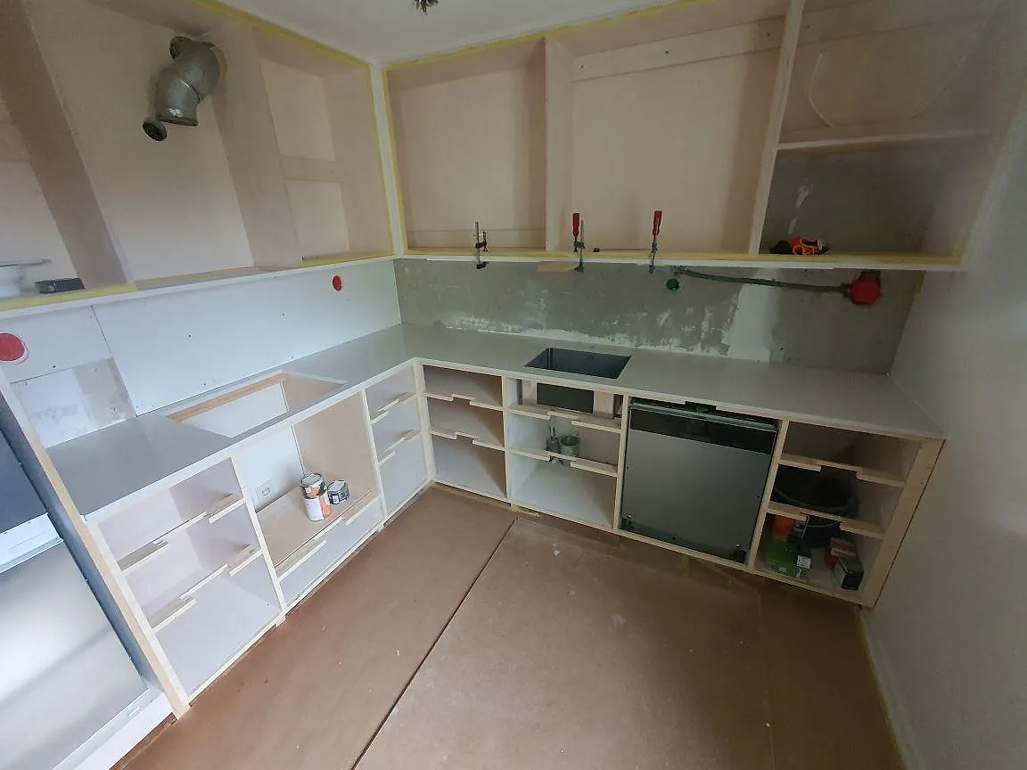 Köksbänkskiva i ljus Silestone Blanco Orion, polerad kvartskomposit, med synliga urtag för diskho och häll i ett kök under montering i Sundbyberg.