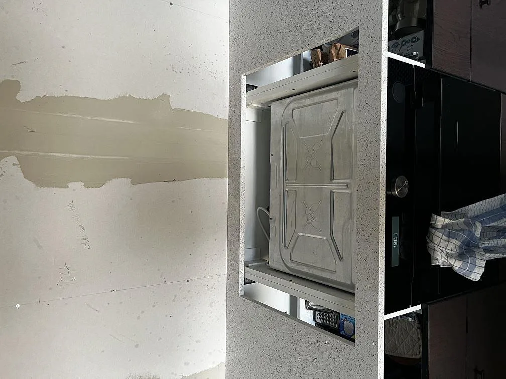 Köksbänkskiva i polerad Silestone Blanco Stellar med hällzon och vit specklad komposityta i Tvååker.