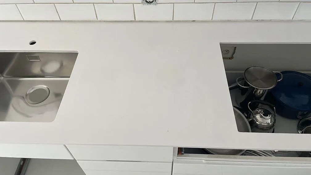 Översikt ovanifrån av vit Silestone Blanco Zeus bänkskiva med diskho och hällöppning i kök i Bunkeflostrand.
