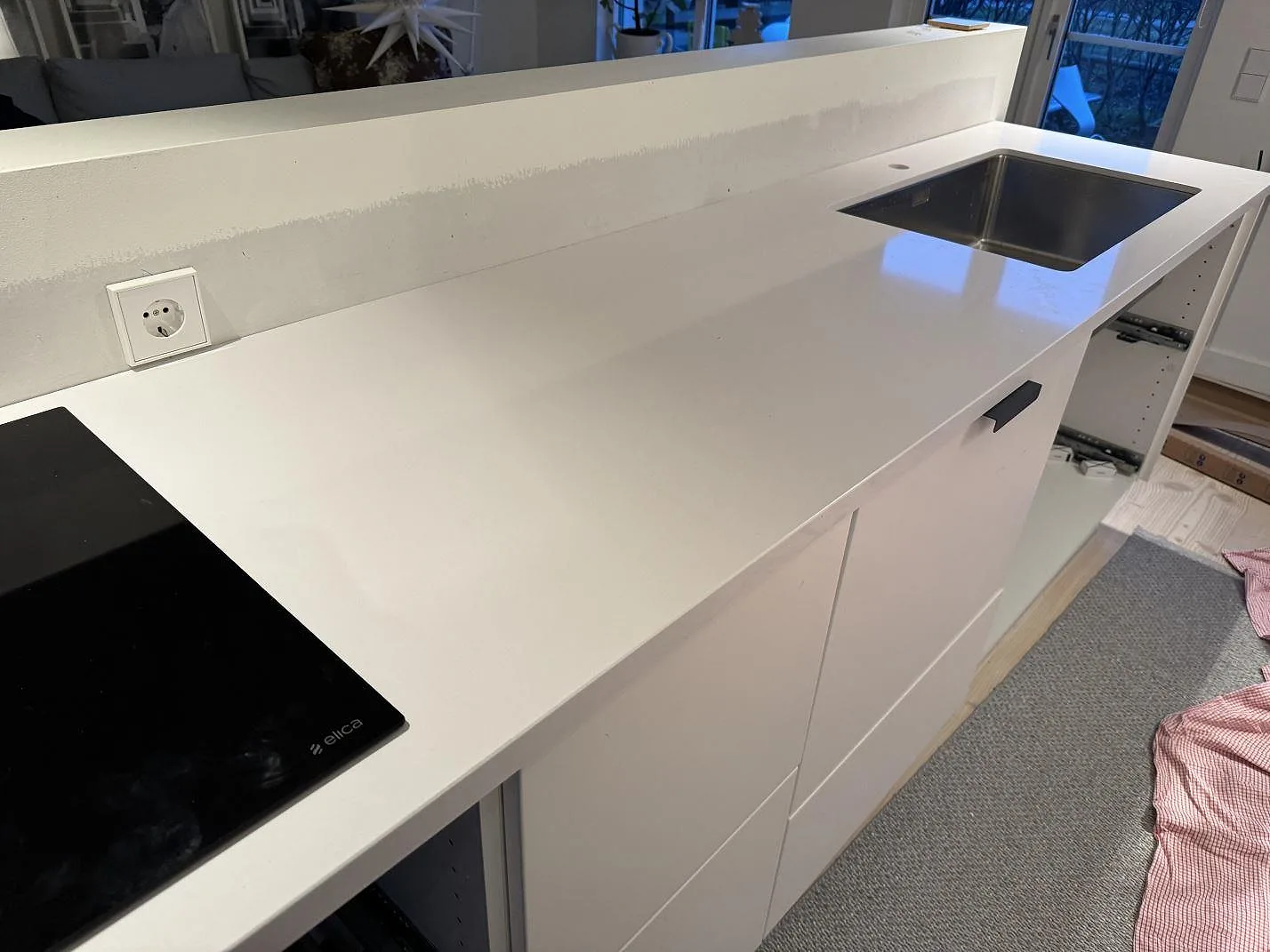 Lång köksbänkskiva i polerad Silestone Blanco Zeus Extreme med slät vit yta, häll och underlimmad diskho i Limhamn.