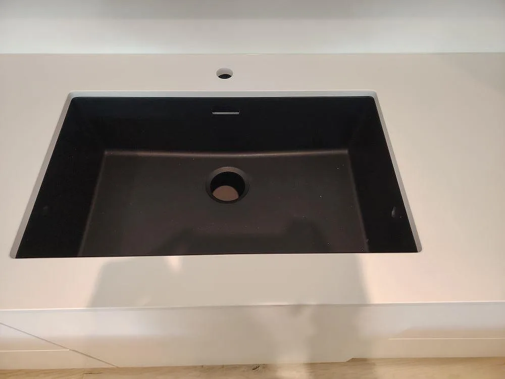 Mörk diskho monterad i vit polerad Silestone Blanco Zeus köksö med blandarhål i Västerås.