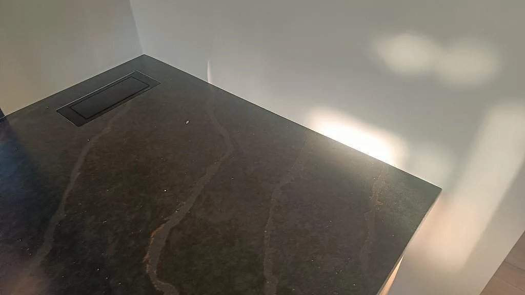 Närbild på matt Silestone Bohemian Flame som installerad köksbänkskiva med mörk ådring och rektangulär detalj i Kävlinge.