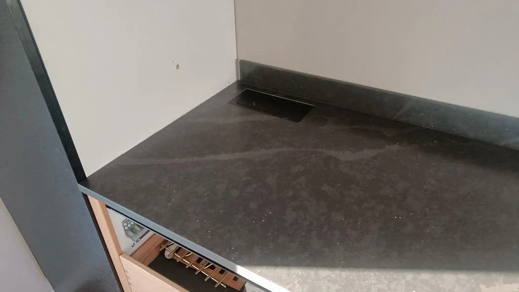 Köksbänkskiva i matt Silestone Bohemian Flame med uppvikt stenstänkskydd och synlig mörk ådring i Kävlinge.