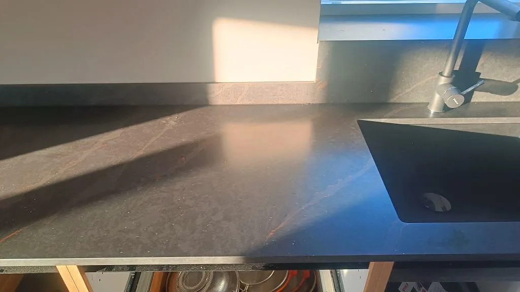 Diskbänksdel i mörk matt Silestone Bohemian Flame med svart underlimmad diskho, blandare och 12 mm stänkskydd i Kävlinge.