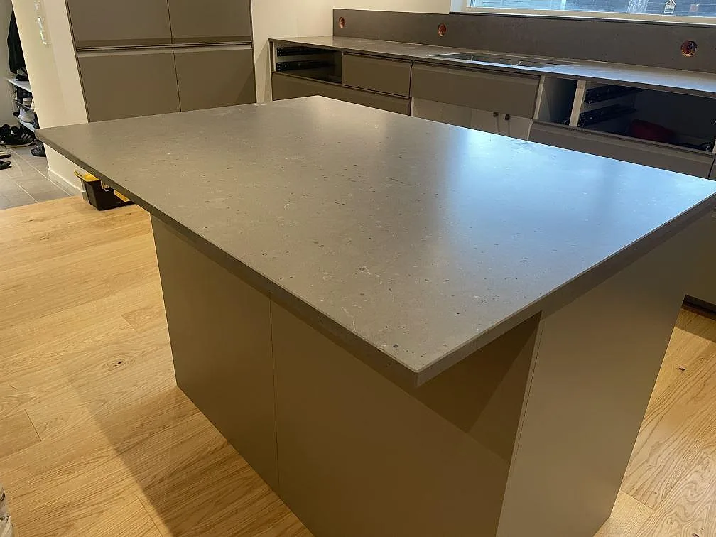 Köksö eller halvö med bänkskiva i Silestone Brass Relish, matt Mocka komposit, i ett kök i Åhus.
