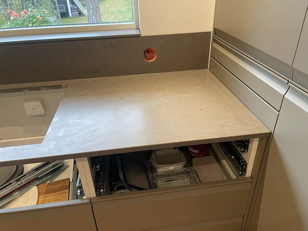 Bänkskiva i Silestone Brass Relish, matt Mocka komposit, vid fönster och högskåp i ett kök i Åhus.