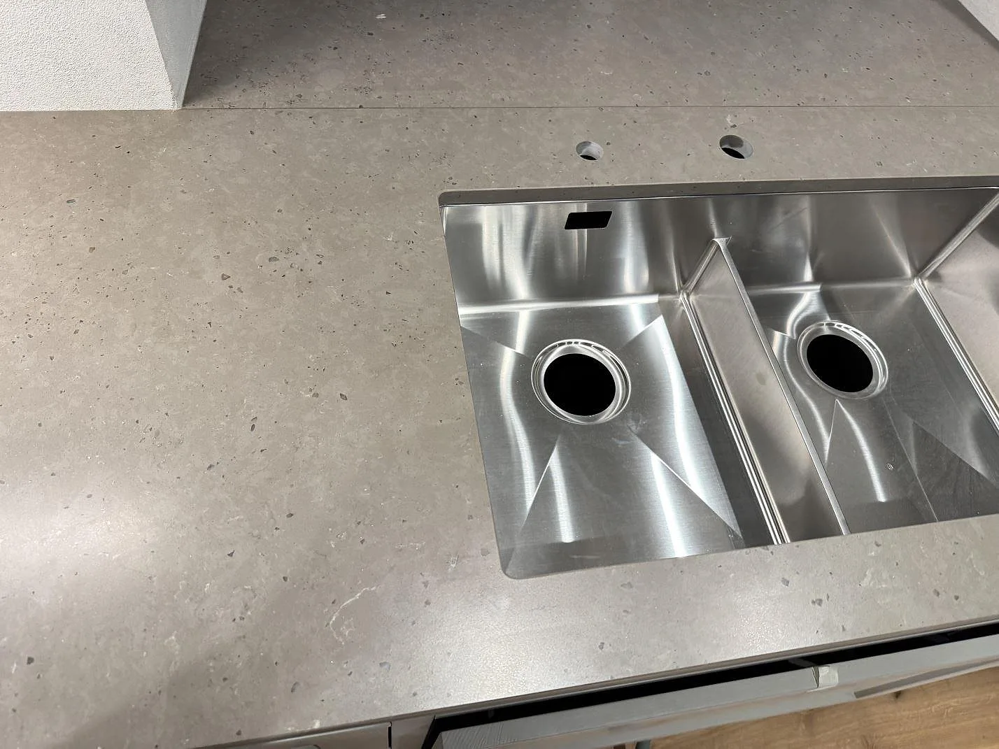 Detalj av Silestone Brass relish bänkskiva runt en rostfri dubbelho i ett kök i Barsebäck.