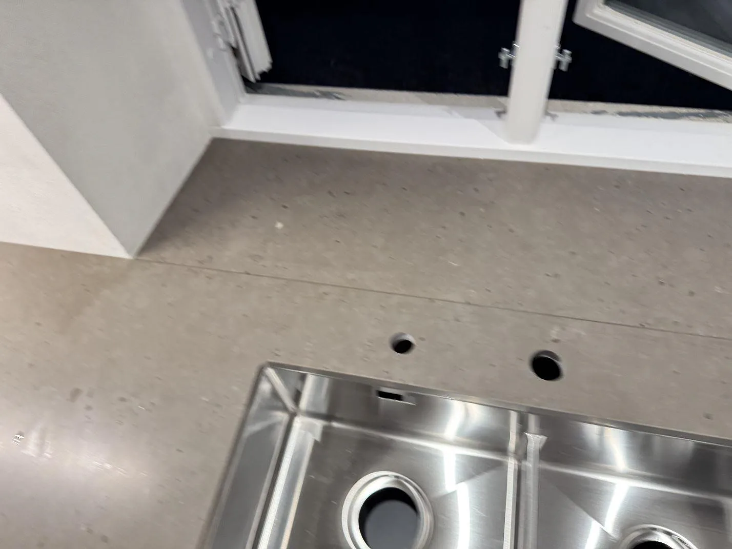 Närbild av matt Silestone Brass relish vid diskho och förborrade hål i köket i Barsebäck.