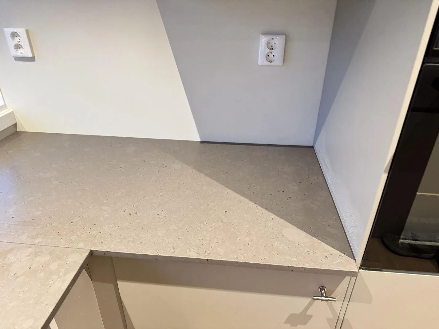 Installerad köksbänkskiva i Silestone Brass relish, matt komposit, längs vägg och hörn i Bjärred.