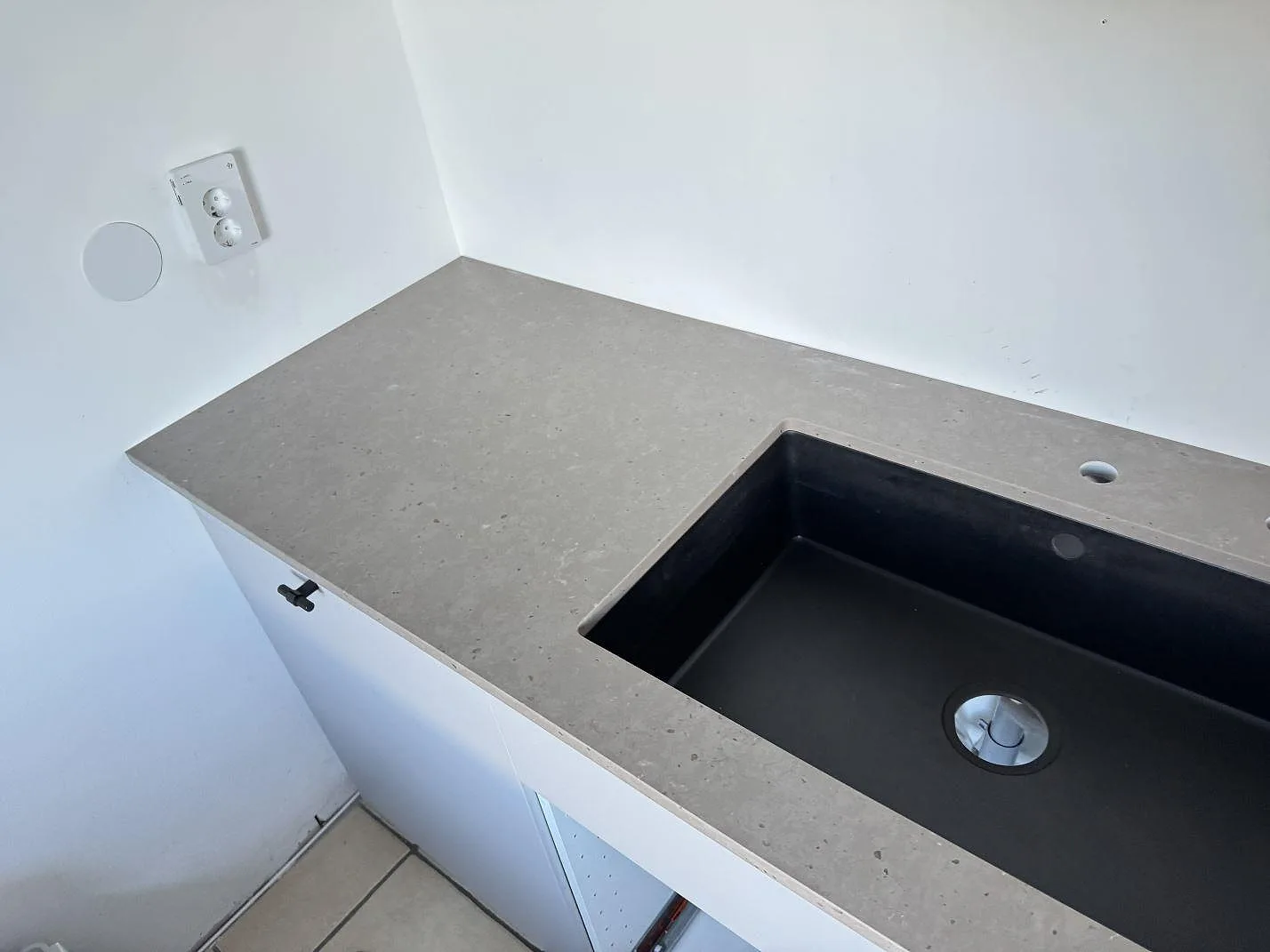 Detalj av diskhoområde och gråbrun Silestone Brass relish som kompositbänkskiva vid vägg i Bunkeflostrand.