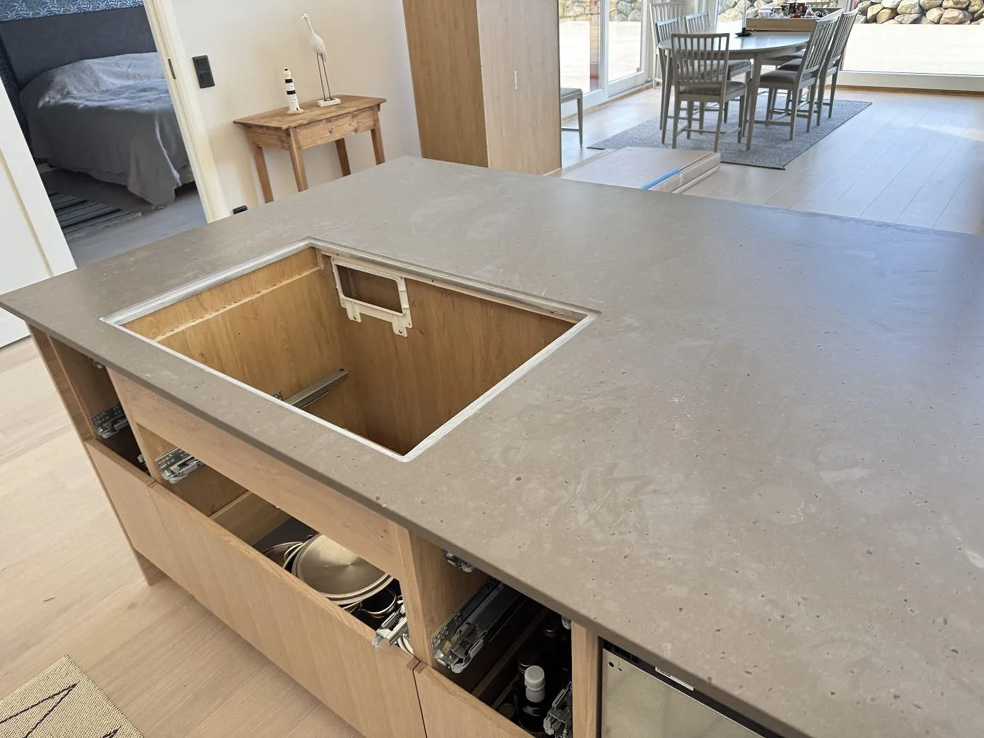Stor köksö med bänkskiva i matt Silestone Brass relish kvartskomposit och förberett hällurtag i ett kök i Glommen.
