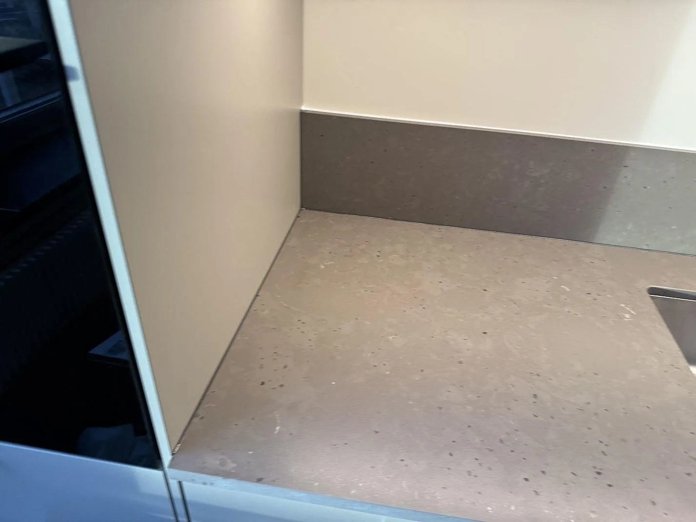 Detalj av installerad köksbänkskiva i Silestone Brass relish med 12 mm stänkskydd och matt komposityta i Göteborg.