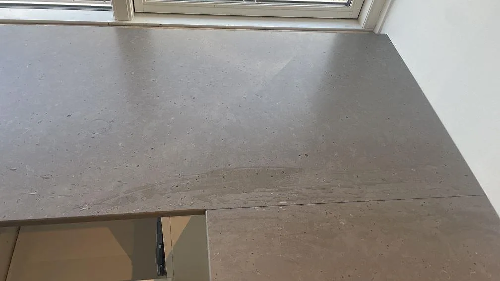 Bänkskiva vid fönster i matt Silestone Brass relish med diskret kornig yta i Hørsholm.