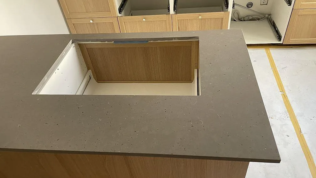 Ovansida av köksö i Silestone Brass relish med matt Mocka-yta och förberedd hällöppning i ett kök i Malmö.