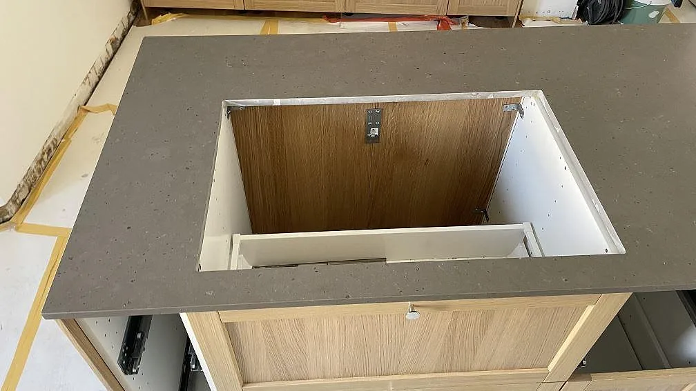 Köksö i Silestone Brass relish, matt Mocka-yta, med stor hällöppning och öppna stommar under montering i Malmö.