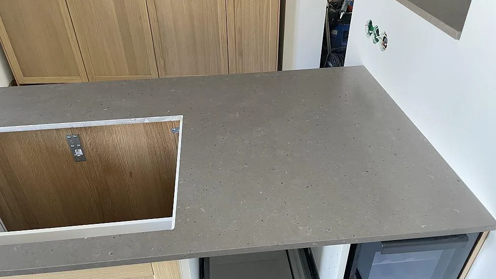 Detalj av den högra delen av köksön i Silestone Brass relish med matt komposityta och hällöppning i Malmö.