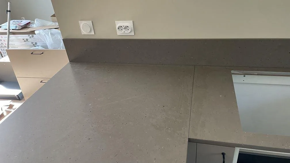 Detalj av Silestone Brass relish bänkskiva och låg stänkkant, matt kvartskomposit, vid arbetsytan i köket i Nättraby.