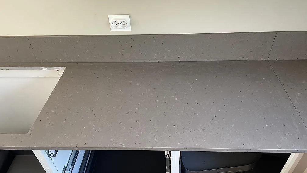 Rak bänkrad i Silestone Brass relish, matt kvartskomposit, med låg stänkkant och öppna köksstommar i Nättraby.
