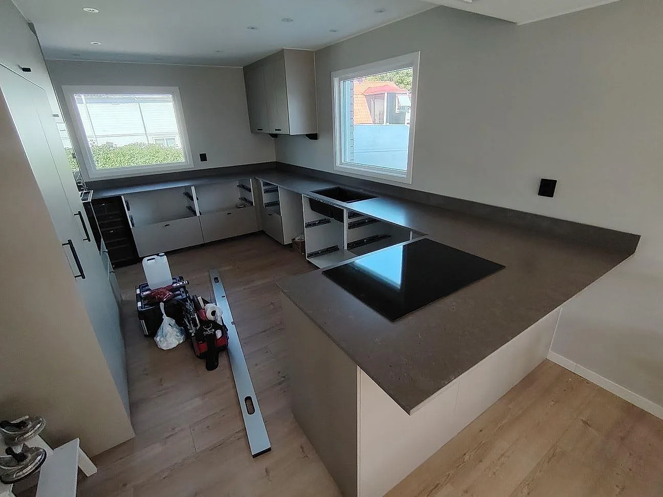 Köksbänkskiva i mörk Silestone Brass relish komposit, matt Mocka-yta, med induktionshäll i ett U-format kök i Västervik.