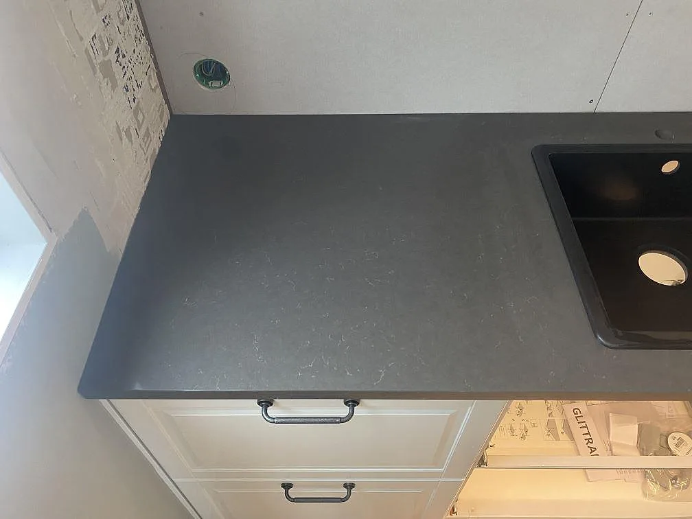 Närbild av polerad Silestone Calypso som köksbänkskiva med svart diskho och synlig ådring i Brålanda.