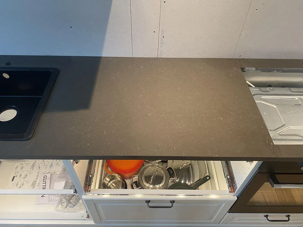 Detalj av polerad Silestone Calypso mellan diskzon och vitvaror, mörk kompositbänkskiva i Brålanda.