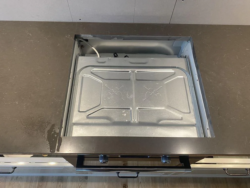Mörk Silestone Calypso som köksbänkskiva runt öppningen för vitvara under montering i Brålanda.