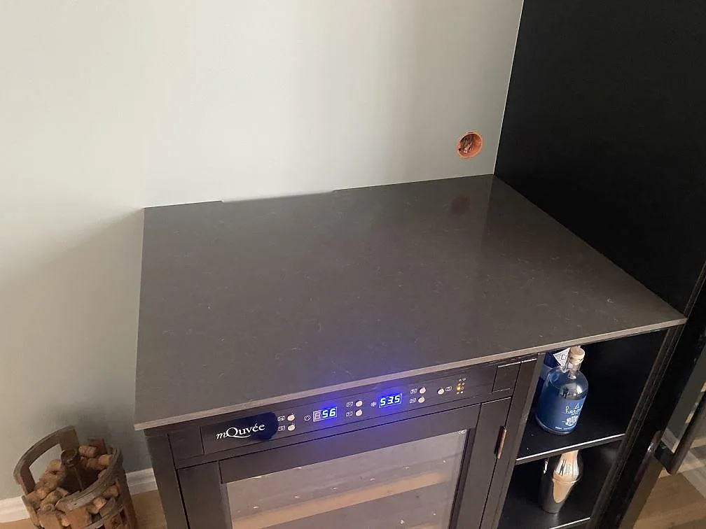 Polerad Silestone Calypso som mörk bänkskiva över dryckeskyl med ljusa ådringar i Brålanda.