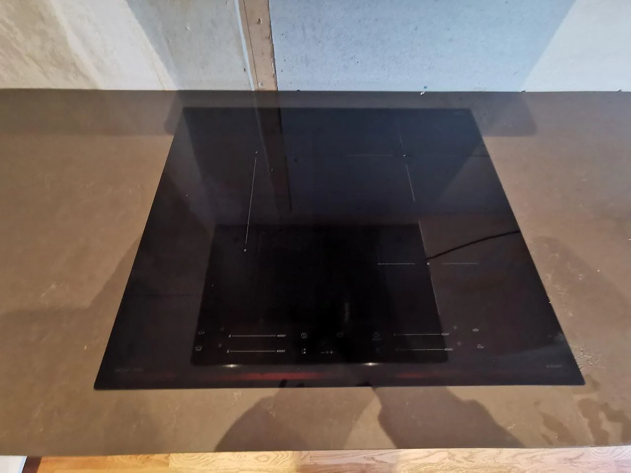 Övermonterad induktionshäll på mörk polerad Silestone Calypso köksbänkskiva i ett kök i Hovås.