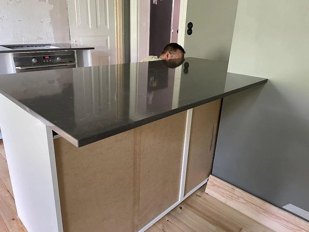 Polerad Silestone Calypso bänkskiva vid vägg med rostfri underlimmad diskho och öppna köksstommar i Malmö.