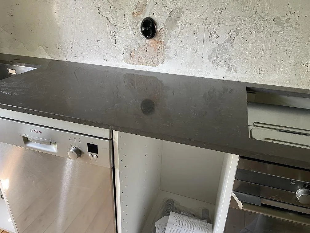 Polerad köksbänkskiva i Silestone Calypso med kökshalvö, diskbänk och hällplats i ett renoveringskök i Malmö.