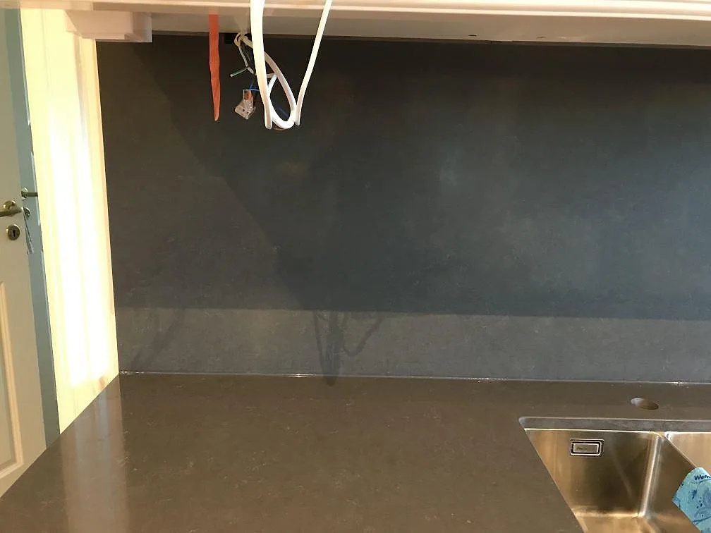 Detalj av köksbänkskiva i Silestone Calypso med diskho, polerad yta och mörkt stänkskydd i Mölndal.