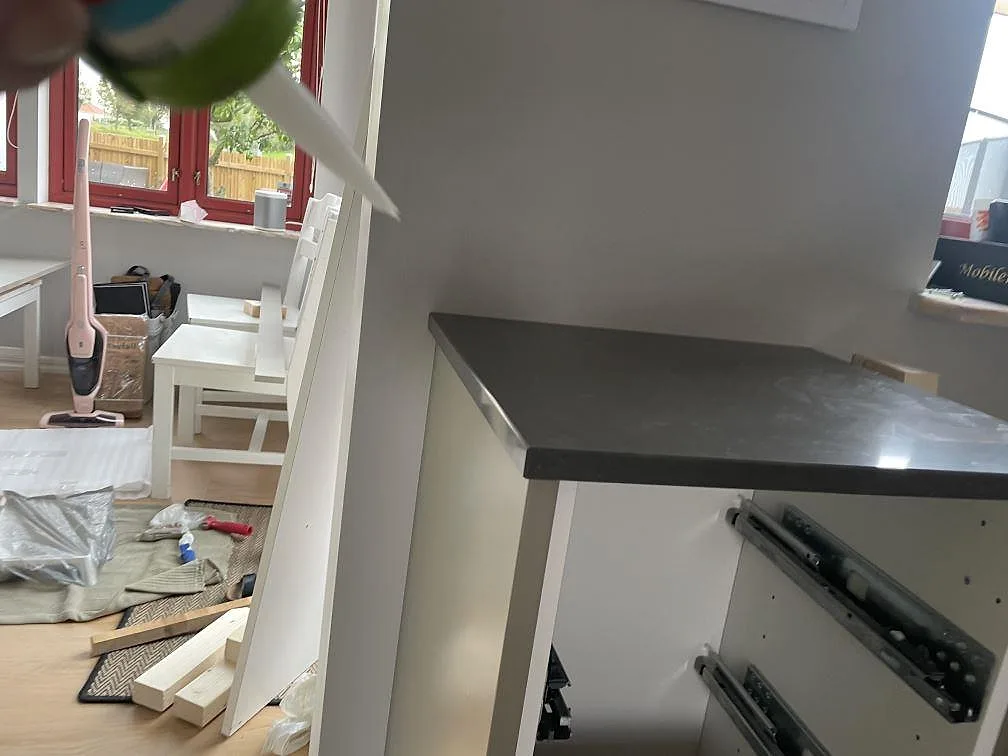 Sidovy av installerad polerad Silestone Calypso på öppen vit skåpstomme under köksmontering i Vintrie.