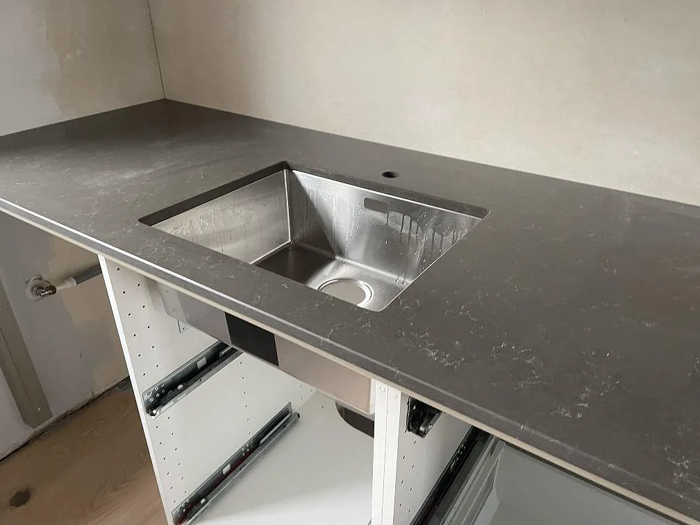Köksbänkskiva i Silestone Calypso med underlimmad rostfri diskho och polerad grå yta i Vintrie.