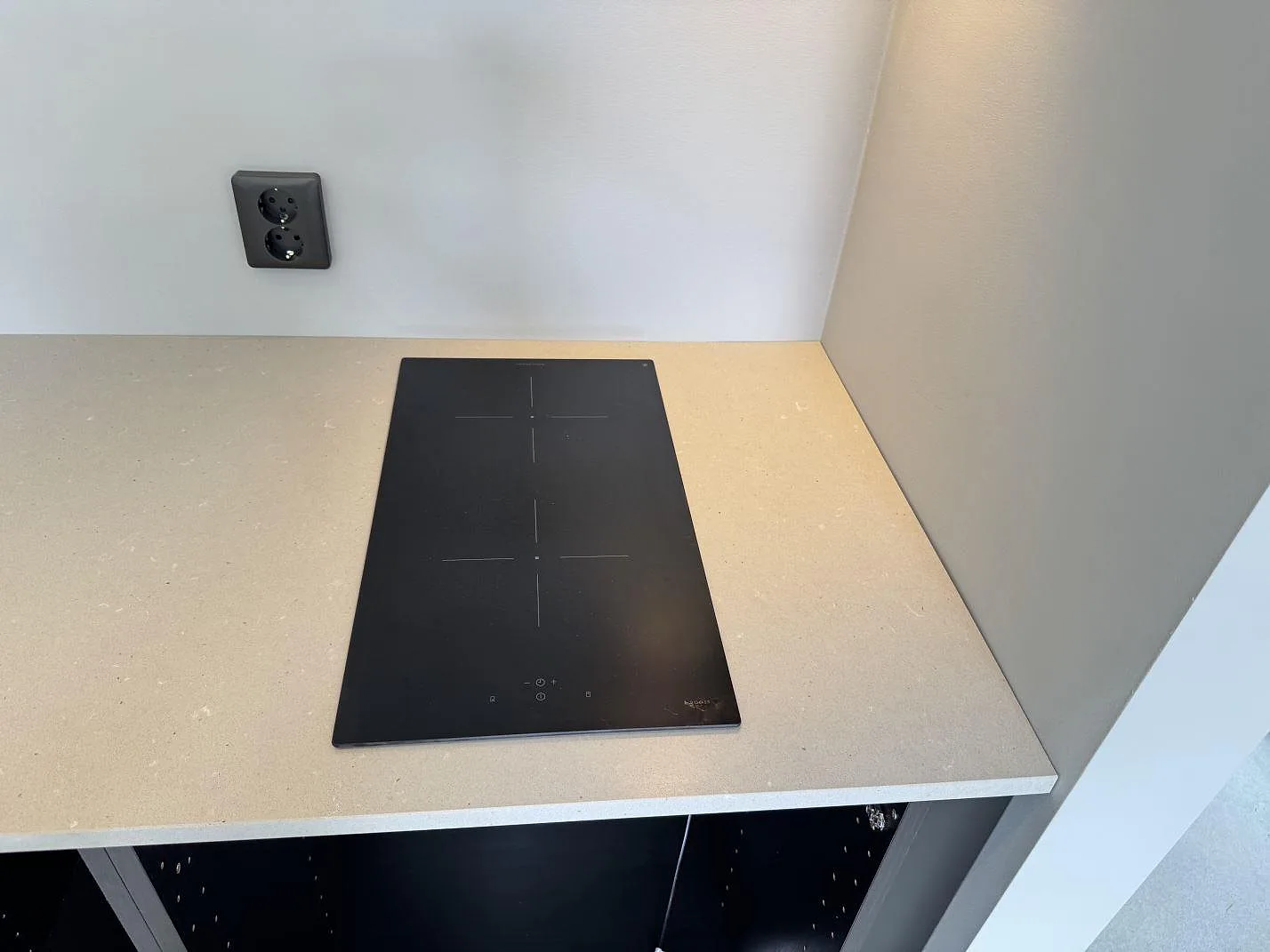 Köksbänkskiva i Silestone Camden, matt Mocka-kvartskomposit, med svart häll och öppen köksstomme i Höllviken.