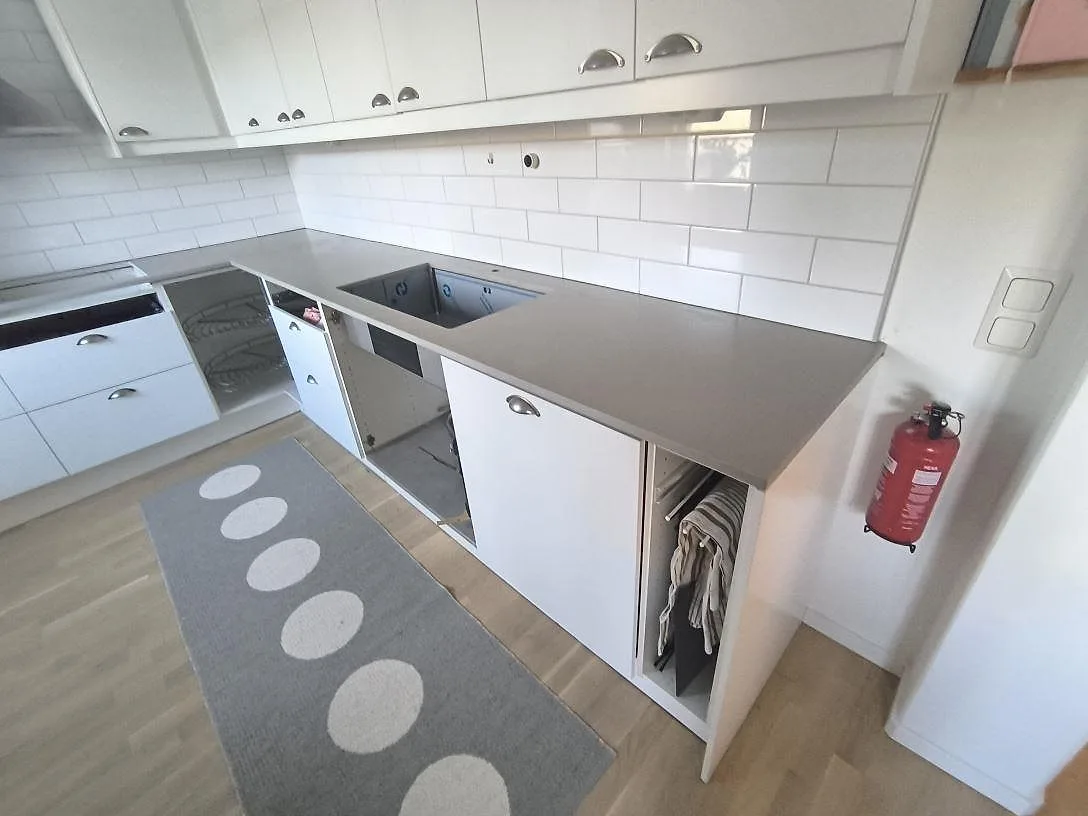 Lång köksbänkskiva i Silestone Camden komposit med matt yta och synliga urtag under montering i Uppsala.