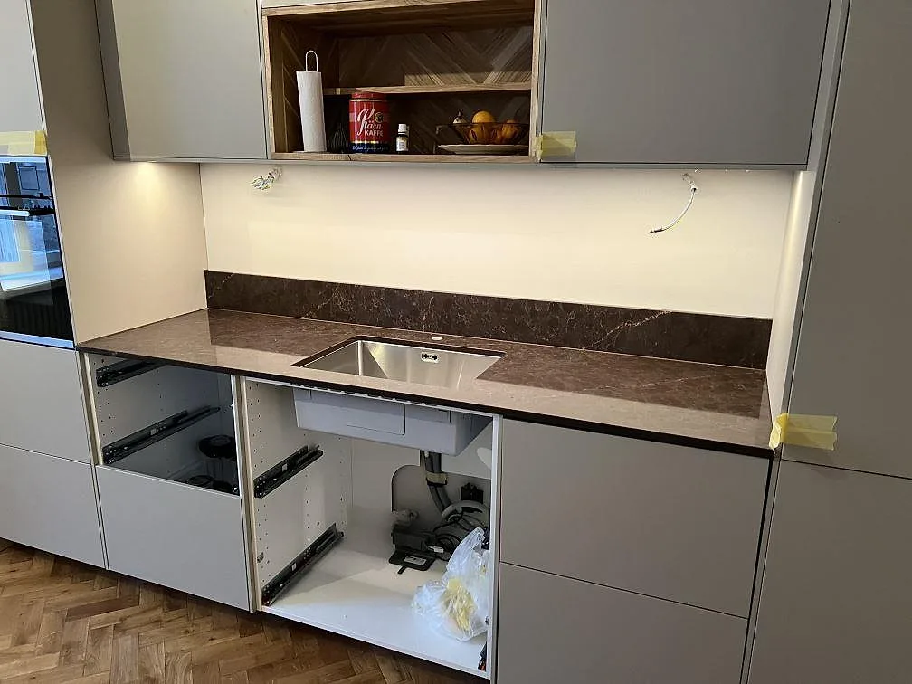 Polerad köksbänkskiva i Silestone Chateau Brown med synlig diskho och uppvikt stänkkant under montering i Stockholm.