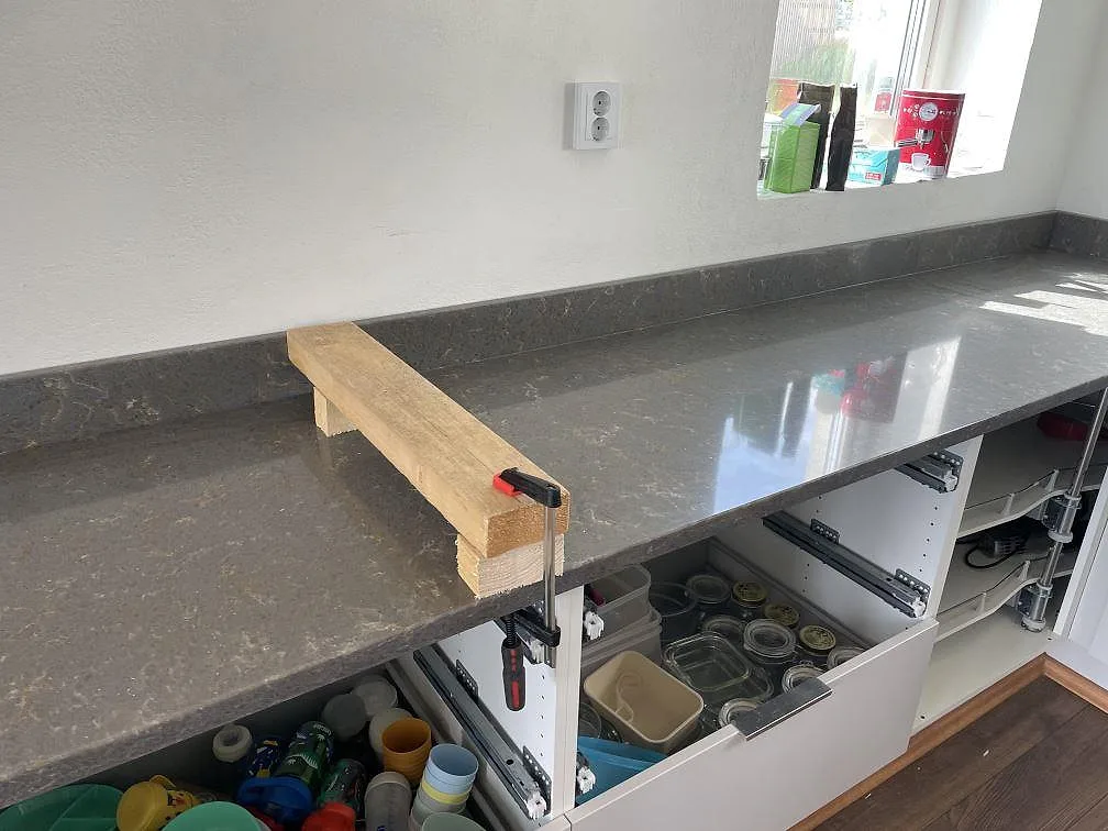 Rak bänkskiva i Silestone Cooper Mist med uppvikt stänkkant, polerad komposityta och fönsterljus i ett kök i Ystad.