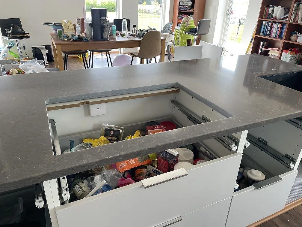 Närbild på polerad Silestone Cooper Mist som köksbänkskiva med förberedd hällöppning och svart diskho i Ystad.