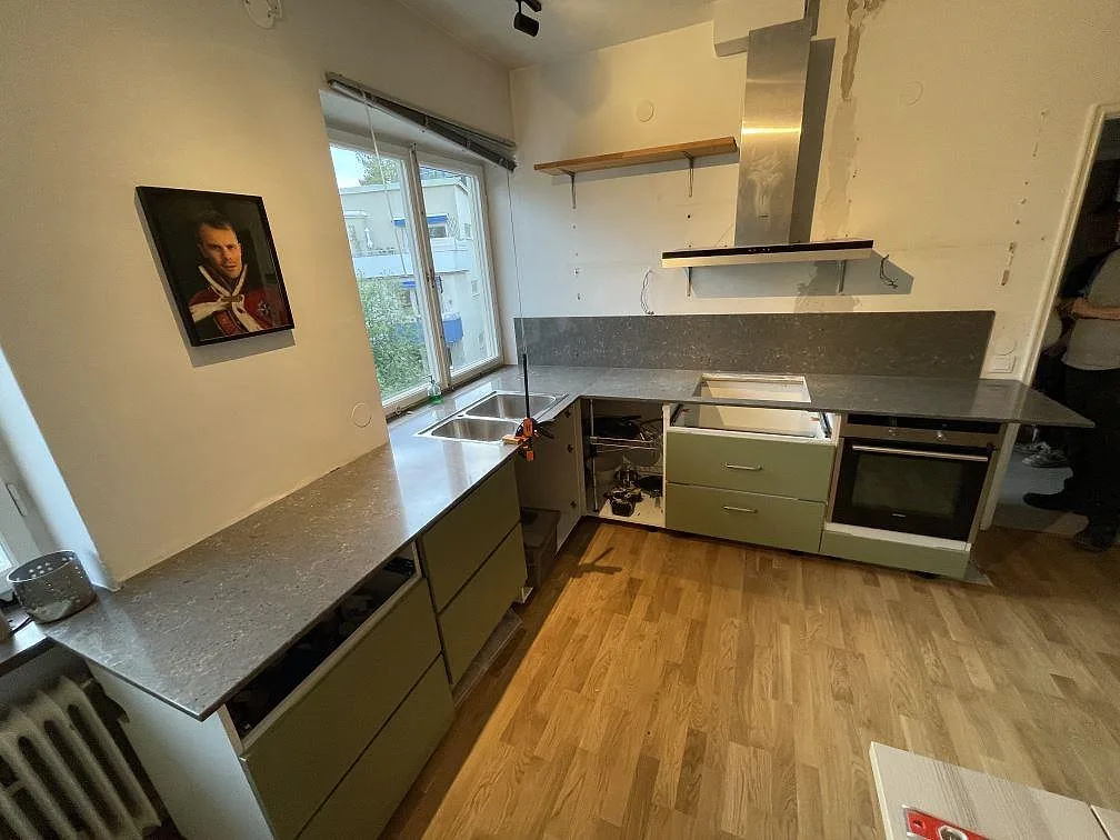 Installerad köksbänkskiva i Silestone Copper Mist med grå melerad yta och väggnära stänkkant i Stockholm.