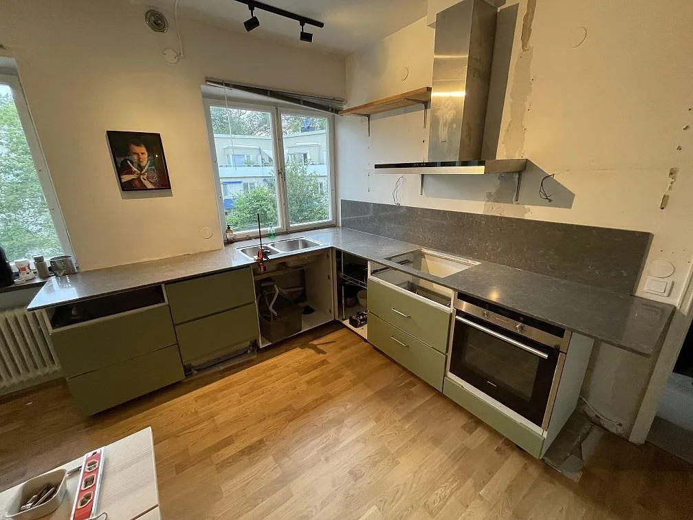 Köksbänkskiva i polerad Silestone Copper Mist, komposit, i ett L-format kök under montering i Stockholm.