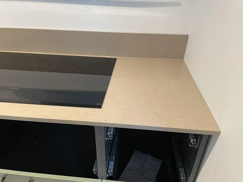 Köksbänkskiva i polerad Silestone Coral Clay komposit med induktionshäll och uppvikt stänkkant i Skurup.