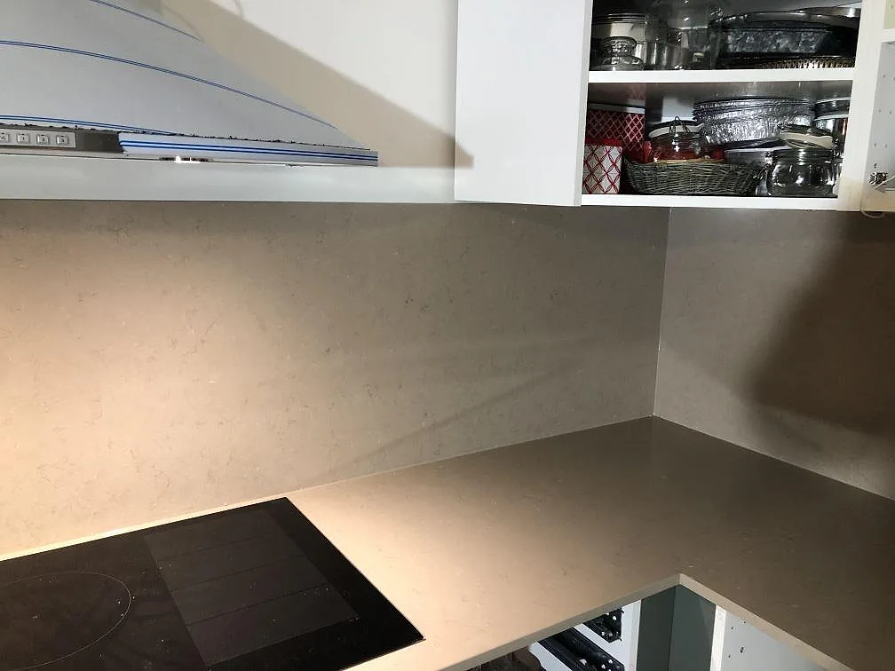 Övermonterad induktionshäll från Siemens i en polerad köksbänkskiva i Silestone Coral Clay med stänkkant i samma sten i ett kök i Åkarp.