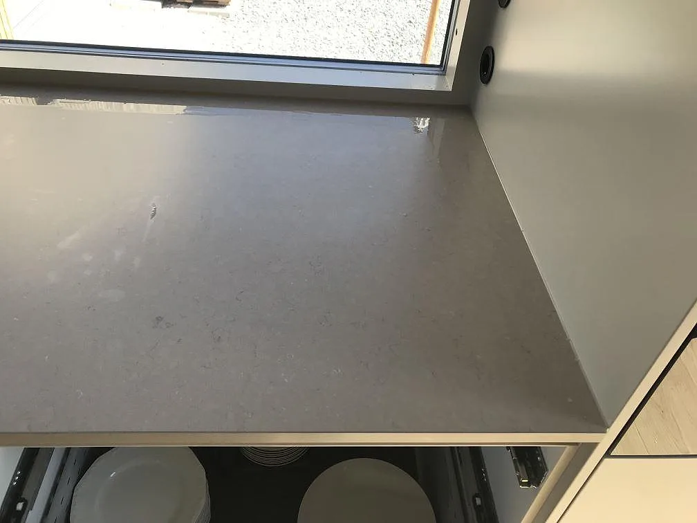 Närbild ovanifrån på en BORA induktionshäll infälld i köksö av matt Silestone Coral Clay i Åsa.