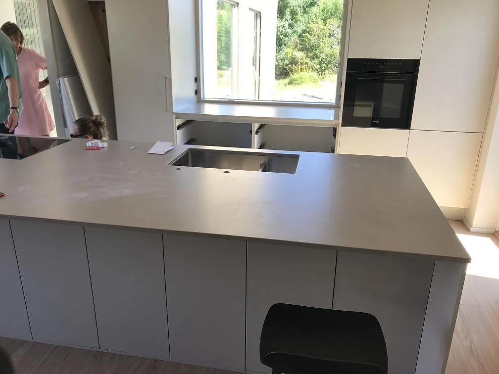 Köksbänkskiva och köksö i matt Silestone Coral Clay, en varm greige kvartskomposit, med undermonterad rostfri diskho i ett kök i Åsa.