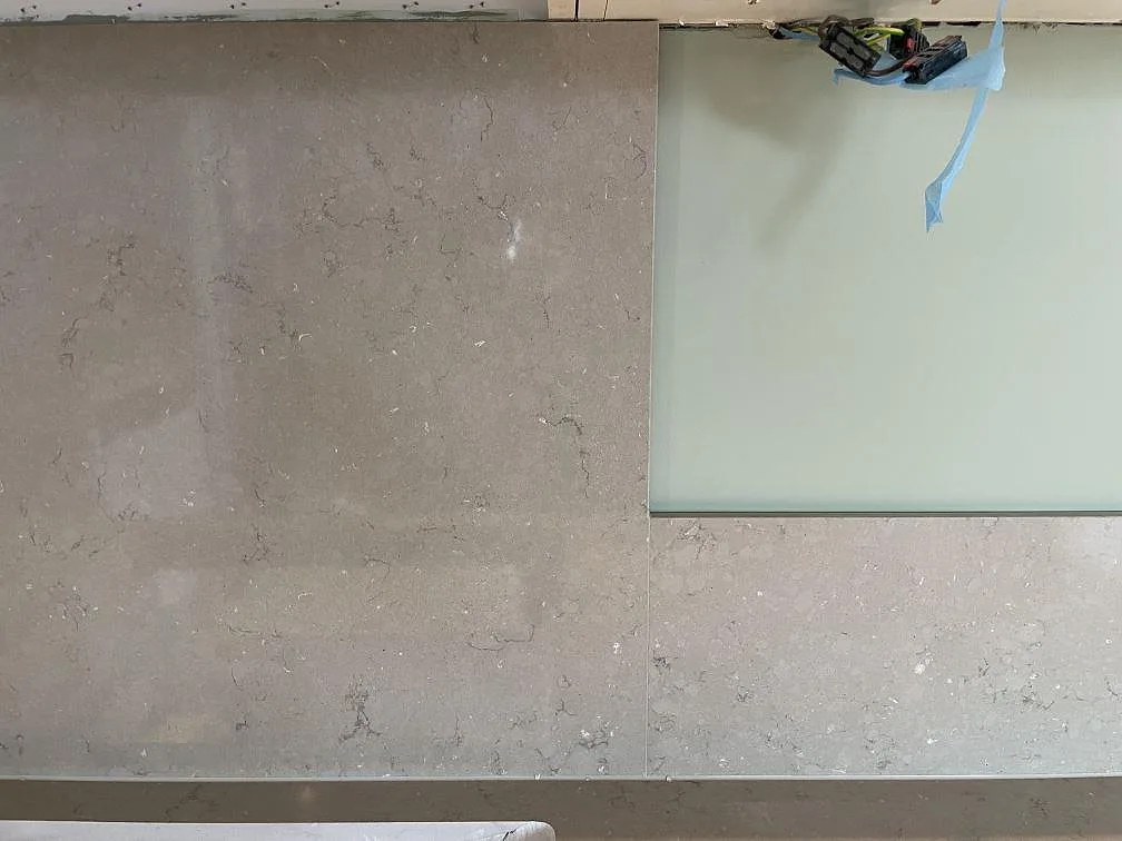 Närbild på den polerade ytan i Silestone Coral Clay, en beige kvartskomposit med diskret ådring, i ett kök i Älta.
